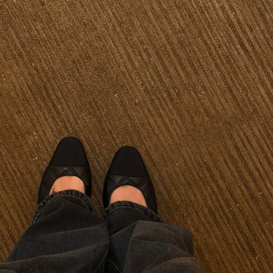 Ballerines noires sur une moquette camel, jean gris — Fursultana Paris